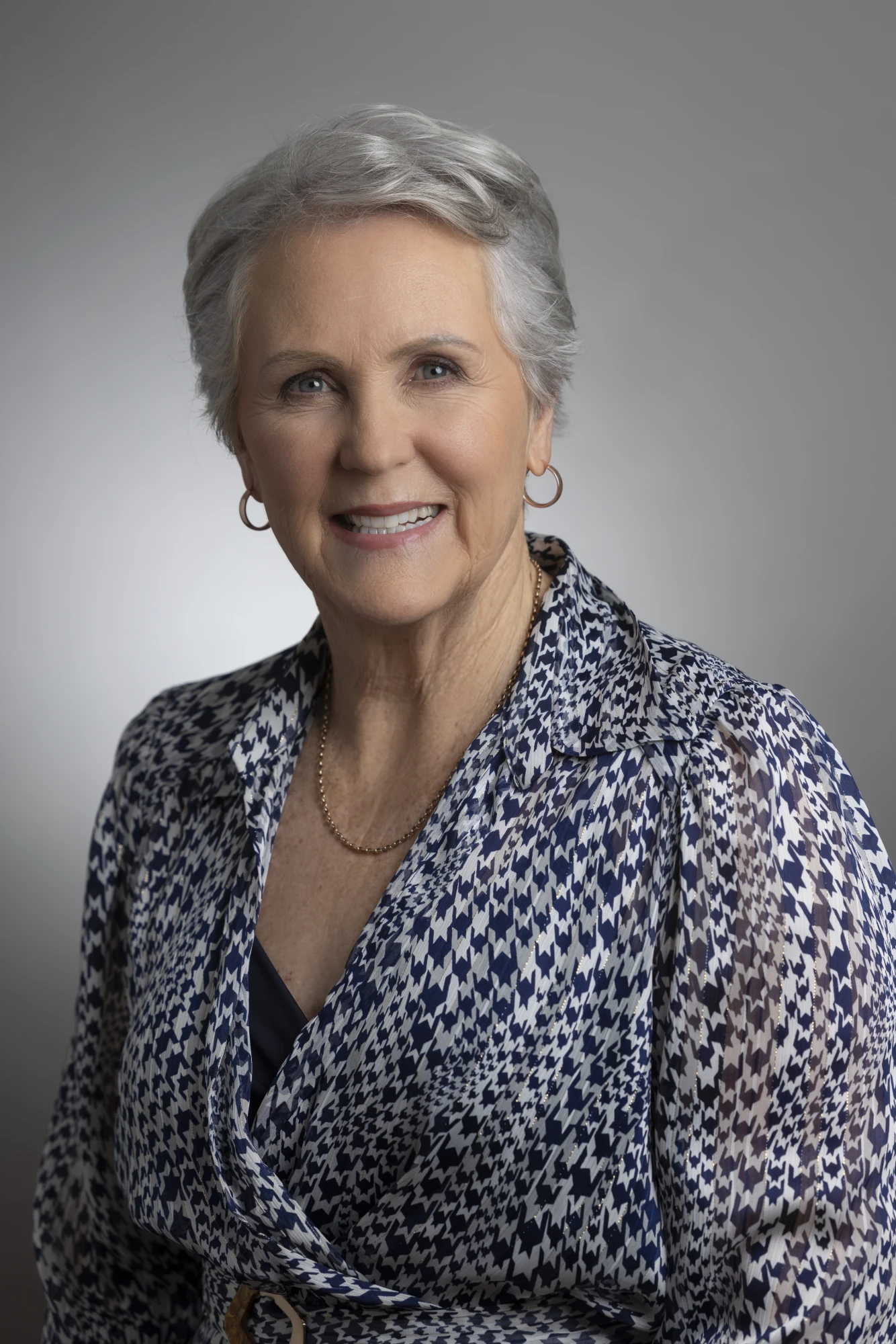 Portrait of Cecilia Moar, memoir coach and editor, smiling in a navy and white patterned blouse