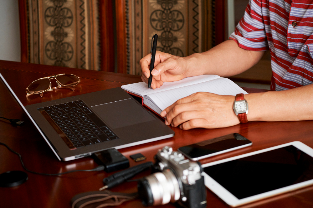 A writer's hands with notes at a desk