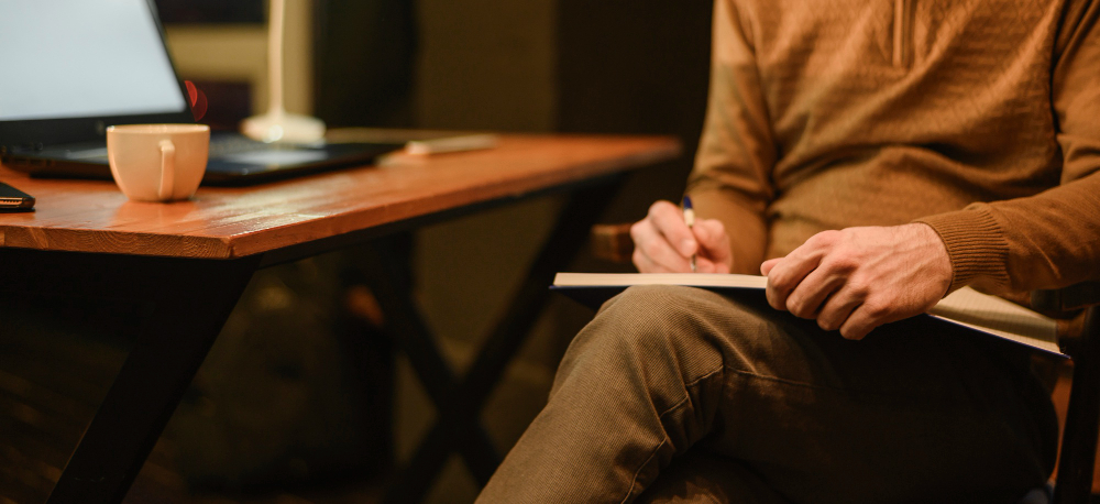 A writer's hands filling a journal, the starting point of memoir coaching